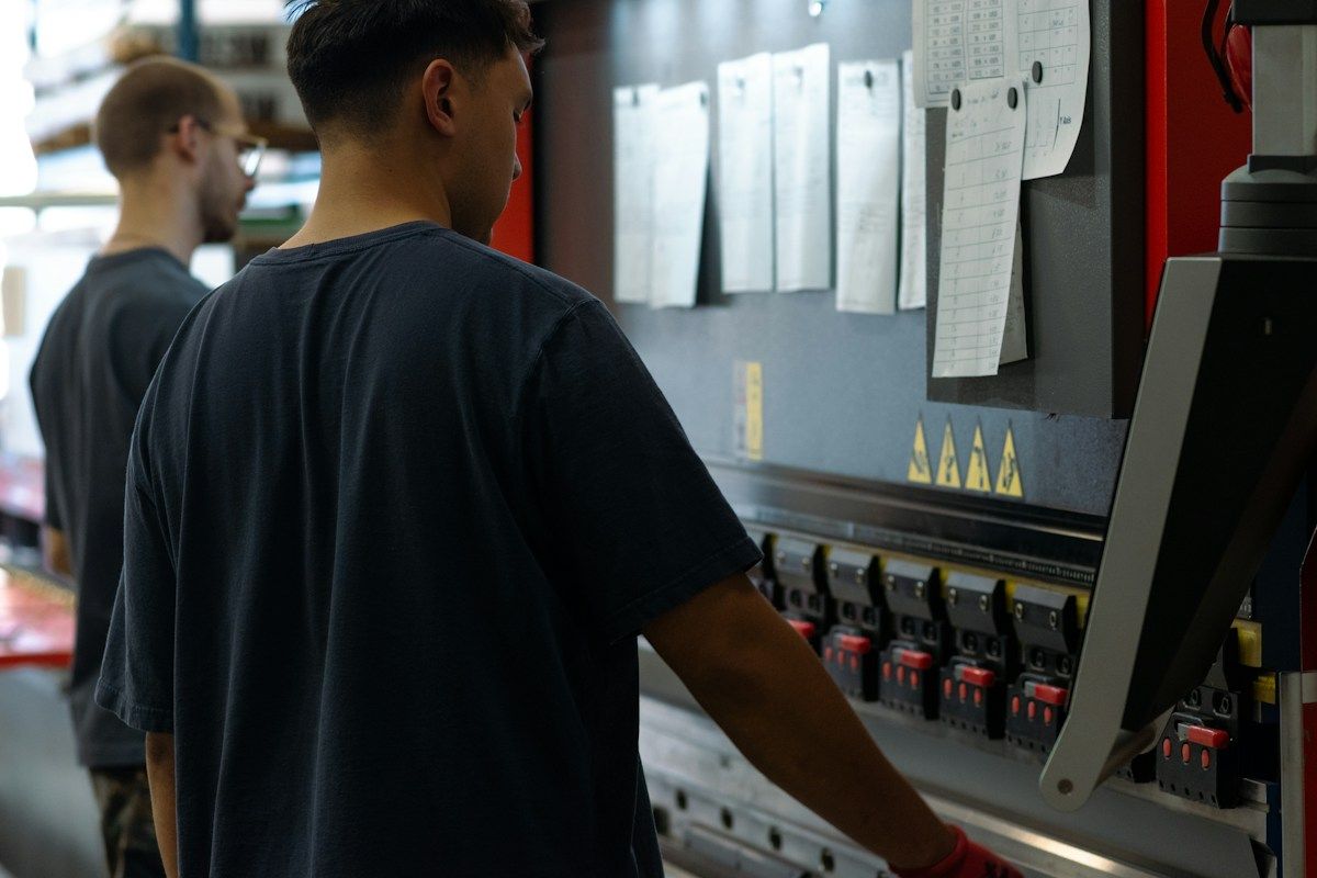 Formateur expliquant le fonctionnement d'une machine à un opérateur