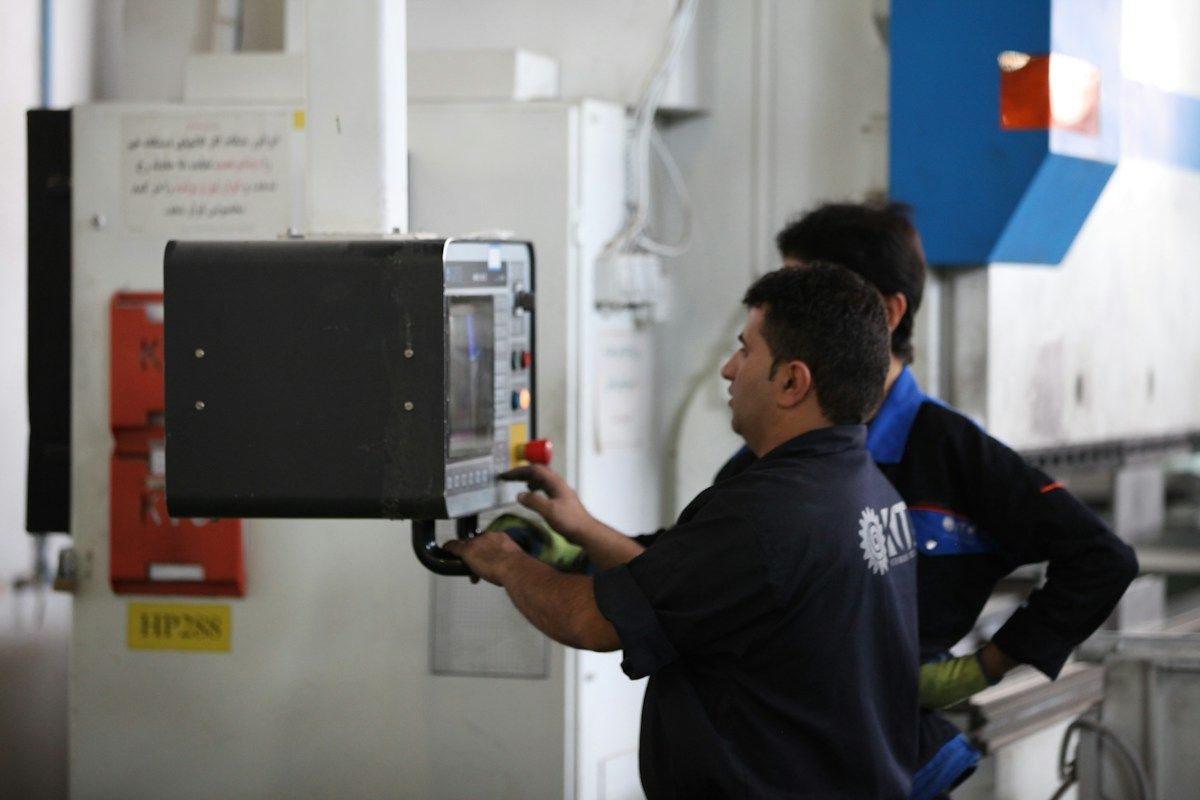 Technicien installant une machine de formage dans un atelier